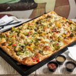 This photo shows a Roman-style pizza topped with