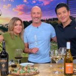 This photo shows Dan Richer in a blue shirt standing between Kit Hoover and Mario Lopez on the set of "Access Hollywood."