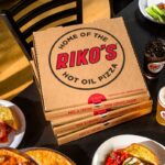 Riko's Pizza Hot Oil Pizza boxes with drinks and appetizers