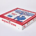 This photo shows Pizza Inn's limited-edition pizza box. The colors are red, white and blue. The key graphics include a banner at the top that reads "250 Years of Honor." Beneath that is a silhouette of a soldier kneeling in grass and holding up a machine gun.