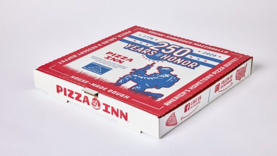 This photo shows Pizza Inn's limited-edition pizza box. The colors are red, white and blue. The key graphics include a banner at the top that reads "250 Years of Honor." Beneath that is a silhouette of a soldier kneeling in grass and holding up a machine gun.