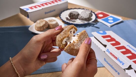 This photo shows a woman's hands breaking open a S'mores Lava Cake to reveal the creamy filling inside.