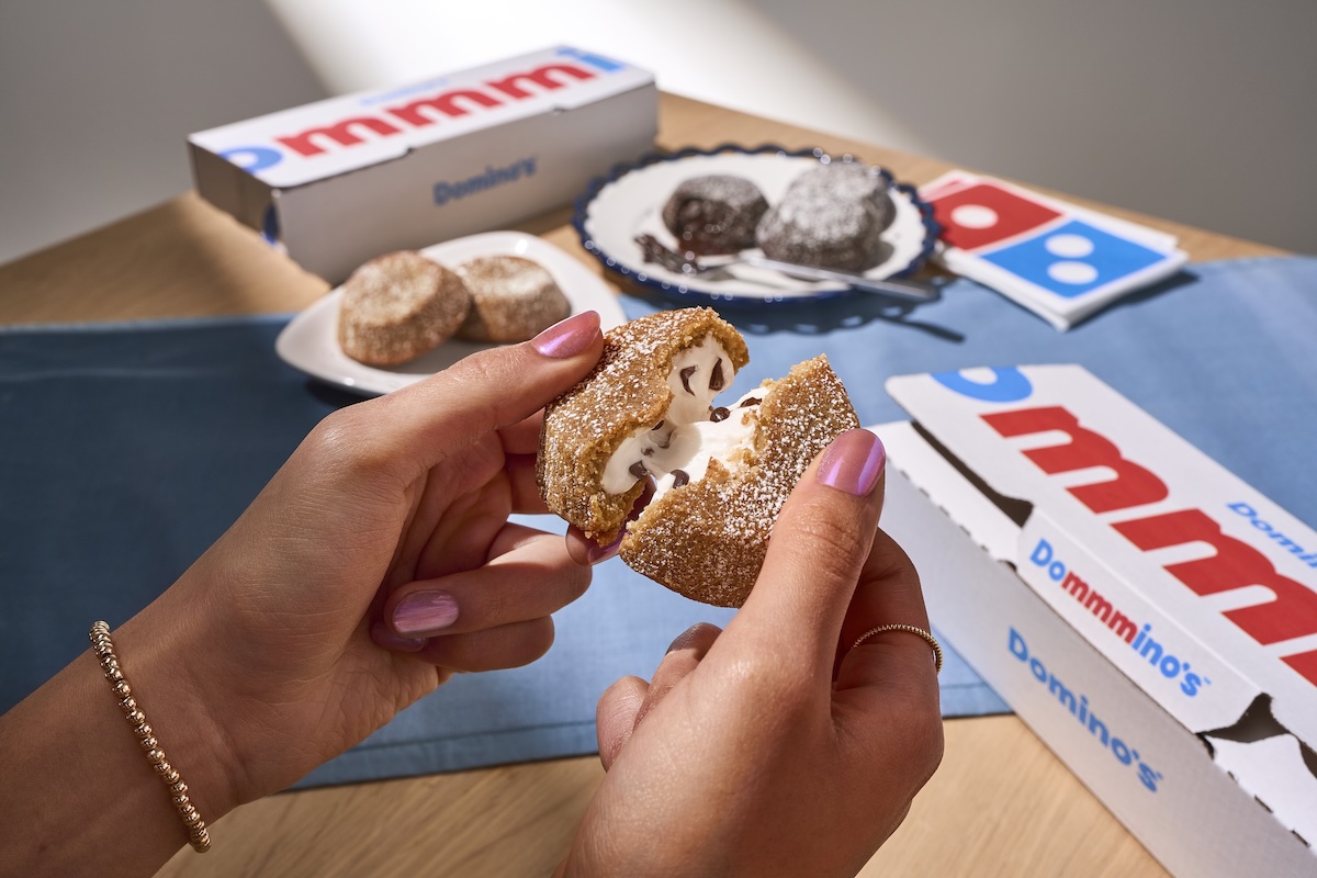 This photo shows a woman's hands breaking open a S'mores Lava Cake to reveal the creamy filling inside.