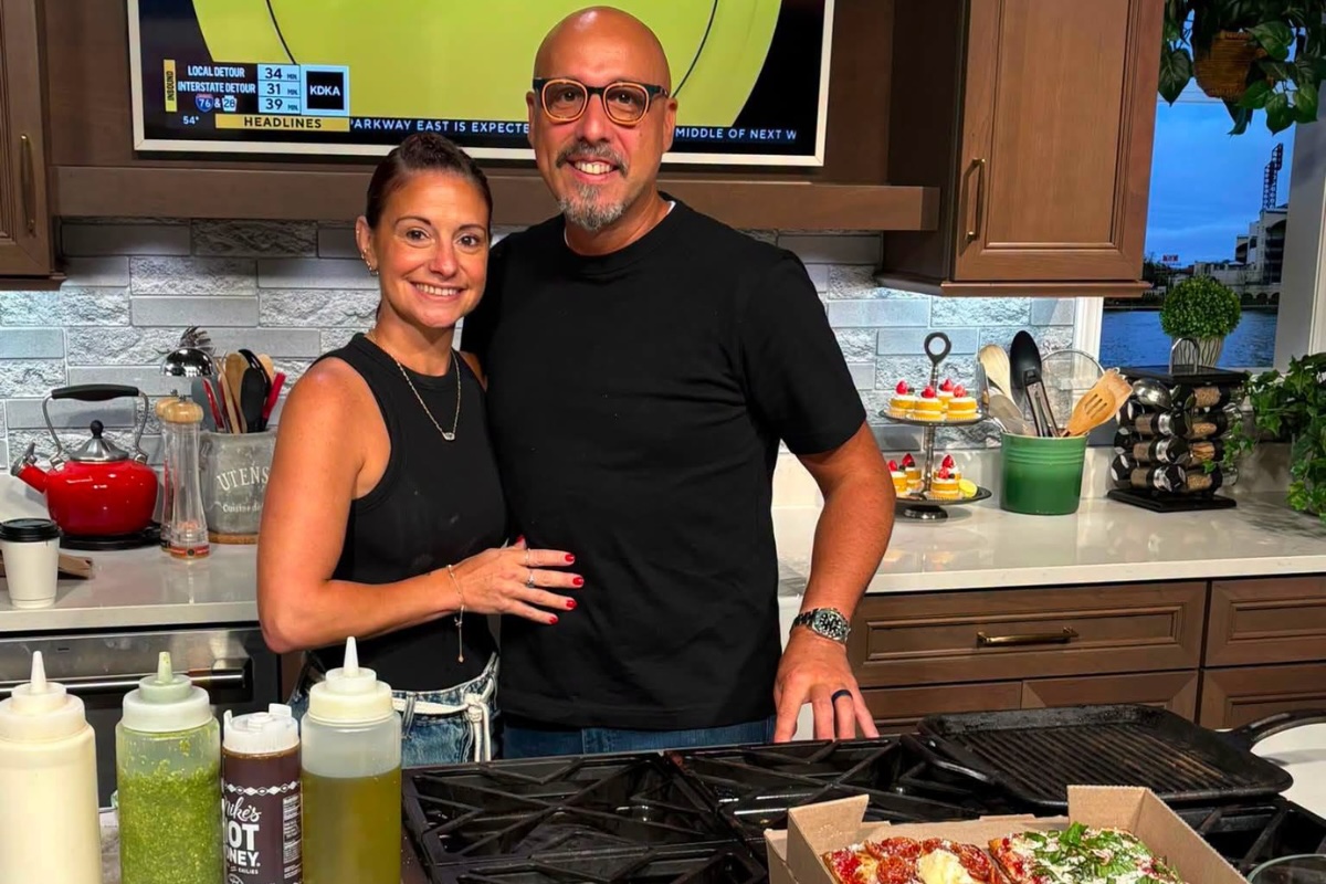 This photo shows Sean Jefairjian and his wife Jessica smiling and standing closely together in their home kitchen.