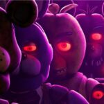 This photo shows a group of creepy animatronic bear characters with glowing red eyes in moody purple lighting.