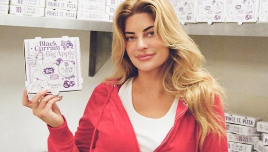 This photo shows Hannah Stockington holding a pizza box for the Black Currant Apple Pie pizza.