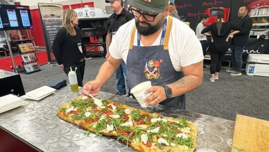 This photo shows Juan Robles making a pizza at a competition.