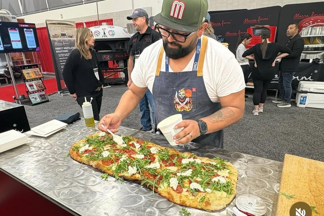 This photo shows Juan Robles making a pizza at a competition.