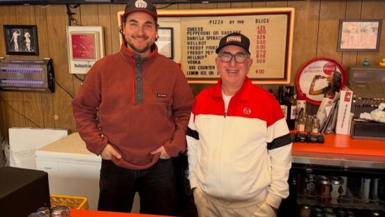 This photo shows Alex Koons and Paul Giannone standing side by side behind the counter at Paulie Gee's in New York.