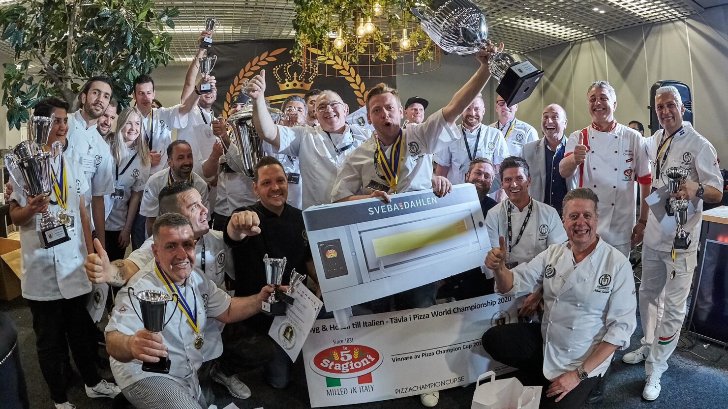 This photo shows a group of competitors, some of them holding trophies, celebrating happily at last year's Pizza Champion Cup in Sweden.