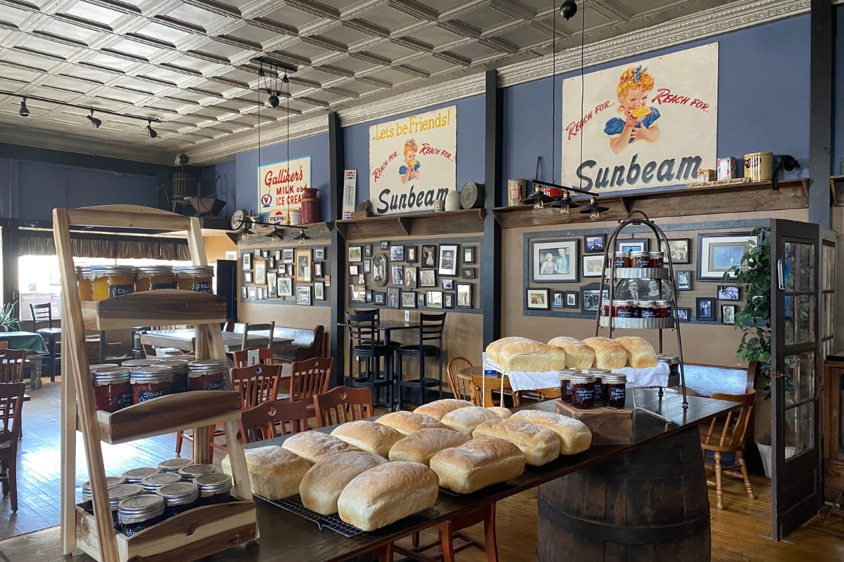 This photo shows the dining room of D'Arc's Pizza with trays of fresh-baked bread on a table in the forefront.