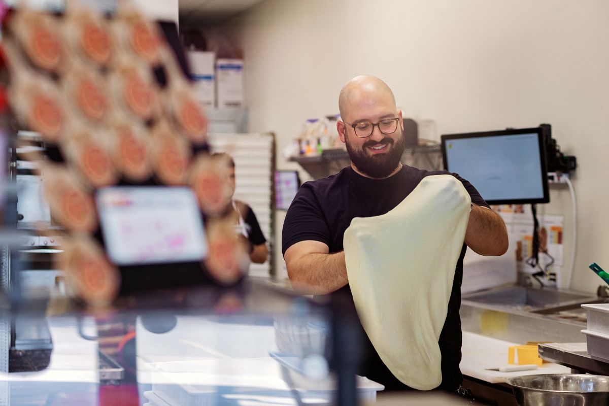 Darius T. Aram, owner and founder of Slice Street Pizza in Dripping Springs, Texas, stretches a dough